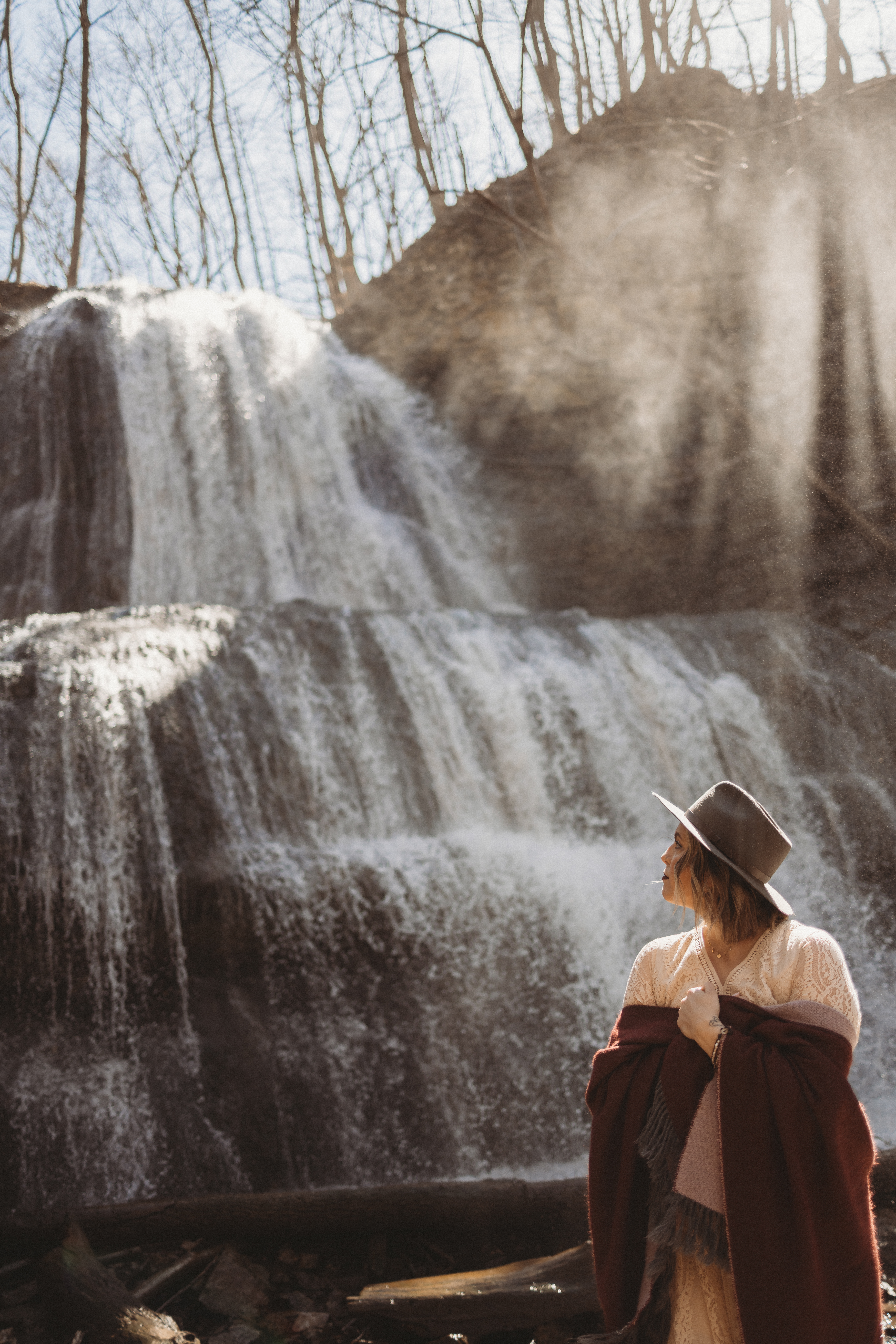 A bride posing at a waterfall for her waterfall wedding adventure elopement